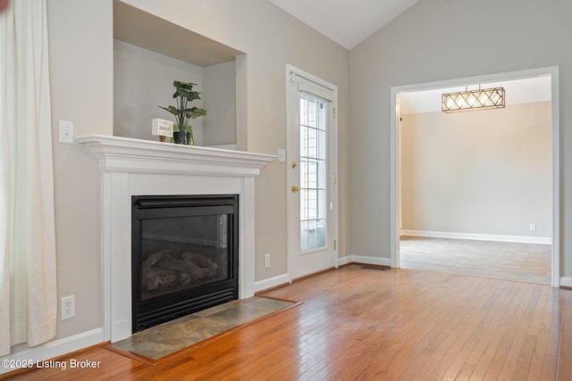 1613 E Crystal Dr, La Grange, KY 40031 - unfurnished living room with wood-type flooring, vaulted ceiling, a glass covered fireplace, and baseboards