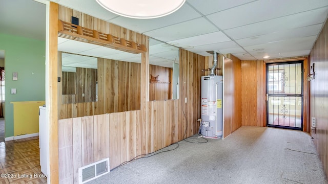 4011 Crawford Ave, Louisville, KY 40218 - unfurnished room with water heater, wooden walls, and a drop ceiling