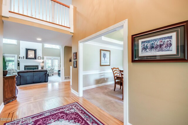 6516 Norman Ct, Crestwood, KY 40014 - hall featuring a towering ceiling, crown molding, baseboards, and light wood-style floors