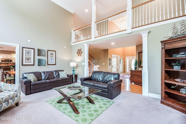 6516 Norman Ct, Crestwood, KY 40014 - carpeted living area with ornate columns, a towering ceiling, stairway, and baseboards