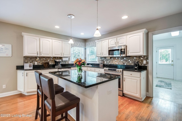 6516 Norman Ct, Crestwood, KY 40014 - kitchen featuring stainless steel appliances, white cabinets, a kitchen breakfast bar, healthy amount of natural light, and recessed lighting
