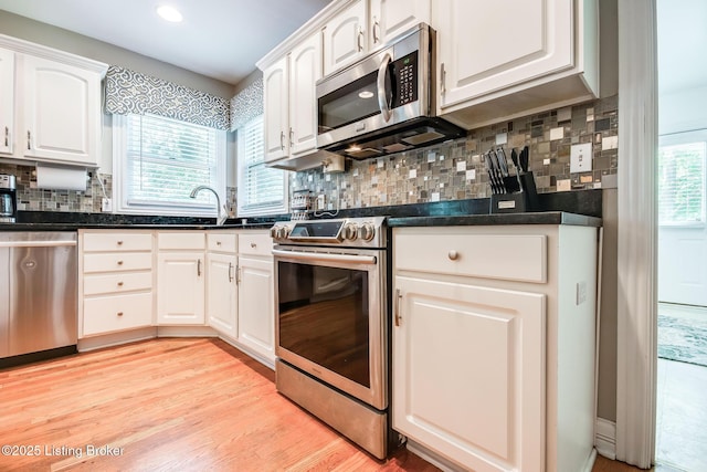 6516 Norman Ct, Crestwood, KY 40014 - kitchen with stainless steel appliances, a sink, white cabinets, tasteful backsplash, and light wood finished floors