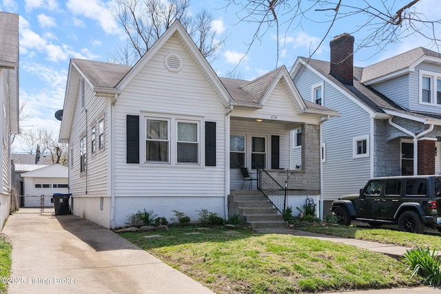634 Ervay Ave, Louisville, KY 40217 - bungalow with a garage, an outbuilding, a chimney, stone siding, and a front yard