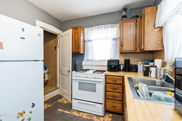 634 Ervay Ave, Louisville, KY 40217 - kitchen with white appliances, light countertops, a sink, and brown cabinetry