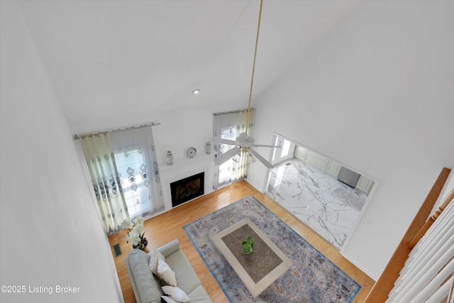 7911 Windgate Dr, Louisville, KY 40291 - living area with wood finished floors, a ceiling fan, a fireplace, and a towering ceiling
