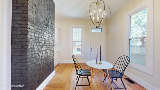 1228 S Floyd St, Louisville, KY 40203 - dining space with light wood-style flooring, a chandelier, and baseboards