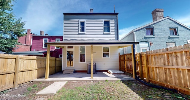 1228 S Floyd St, Louisville, KY 40203 - rear view of property with a patio, a fenced backyard, and a chimney