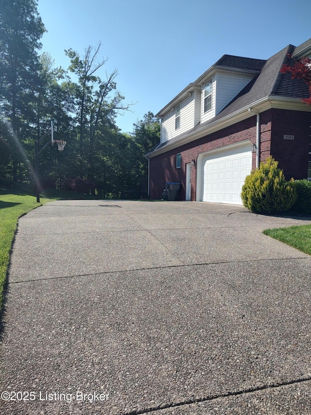 3501 Hardwood Forest Dr, Louisville, KY 40214 - view of side of home featuring a garage, driveway, and brick siding