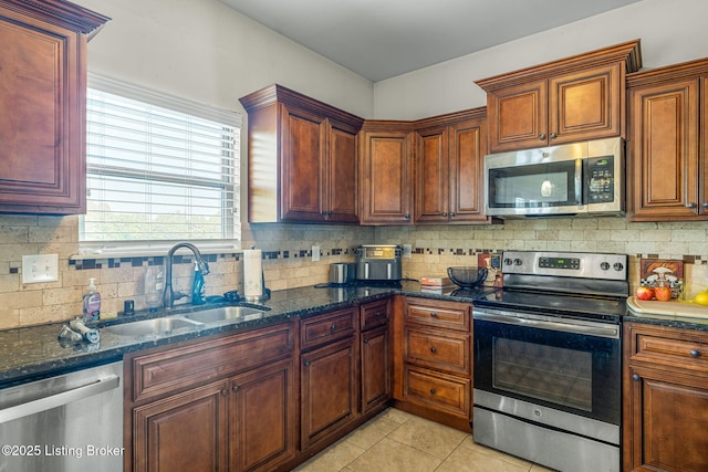 218 Sangria Dr, Vine Grove, KY 40175 - kitchen featuring appliances with stainless steel finishes, a sink, decorative backsplash, light tile patterned floors, and dark stone counters