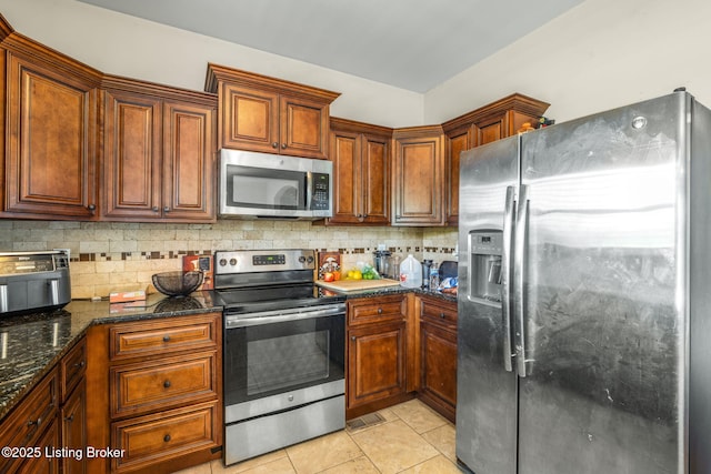 218 Sangria Dr, Vine Grove, KY 40175 - kitchen with stainless steel appliances, decorative backsplash, light tile patterned floors, dark stone countertops, and brown cabinets
