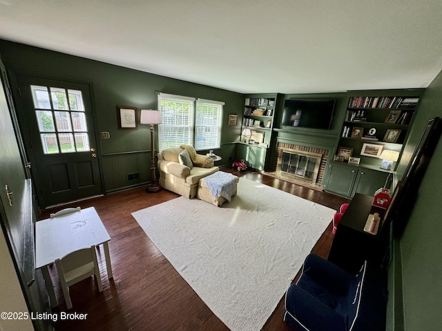 8602 Banbridge Rd, Louisville, KY 40242 - living room featuring dark wood-style flooring, a fireplace, and a wainscoted wall