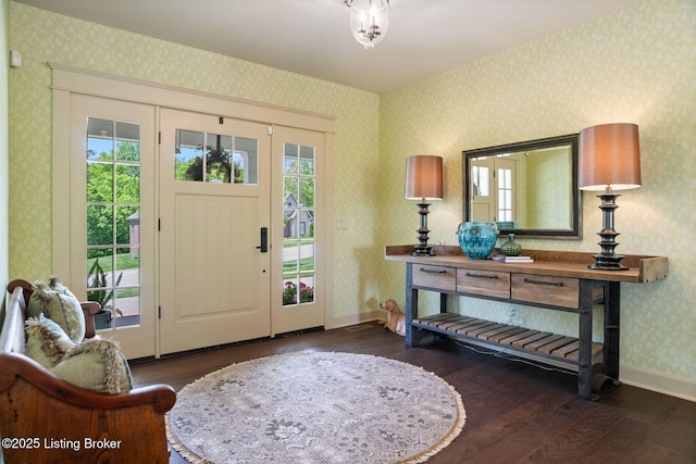 entryway with wallpapered walls, hardwood / wood-style floors, healthy amount of natural light, and baseboards