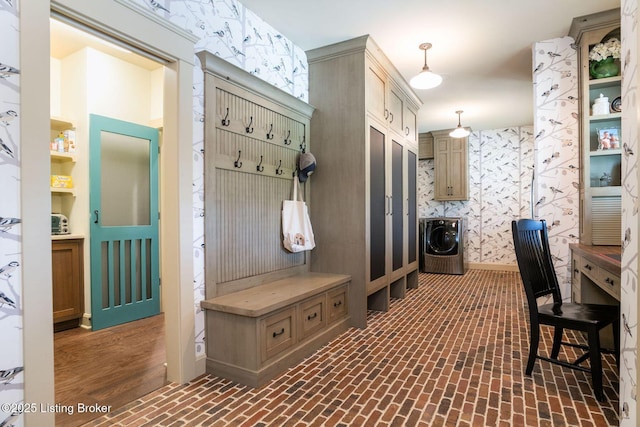 mudroom featuring brick flooring, washer / dryer, and wallpapered walls