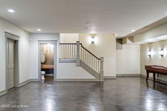 unfurnished living room with recessed lighting, concrete floors, baseboards, and stairs