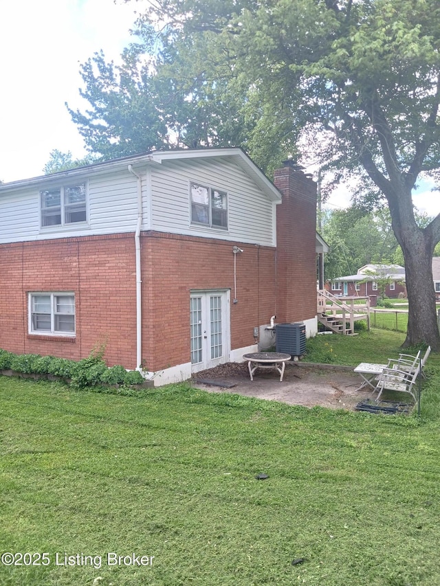 7702 Edna M Rd, Louisville, KY 40258 - rear view of property with french doors, brick siding, a chimney, a patio area, and central AC unit