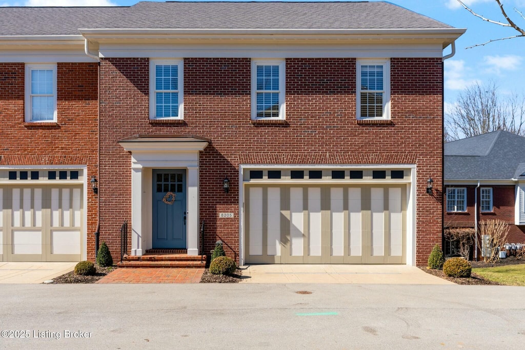 8205 Maris Ct, Louisville, KY 40241 - view of front of home with brick siding, driveway, an attached garage, and roof with shingles