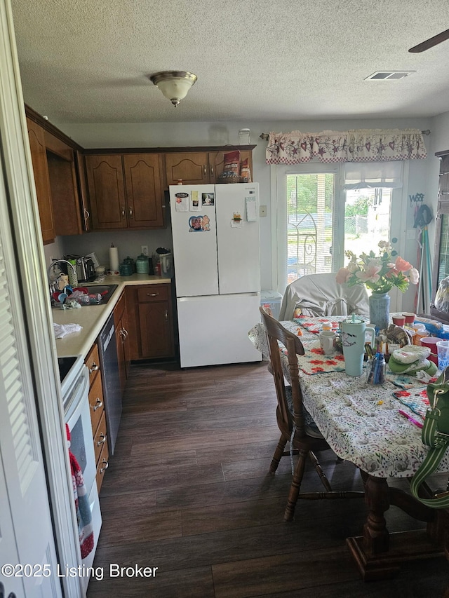 100 Monroe St, Radcliff, KY 40160 - kitchen featuring white appliances, dark wood-type flooring, a textured ceiling, and light countertops