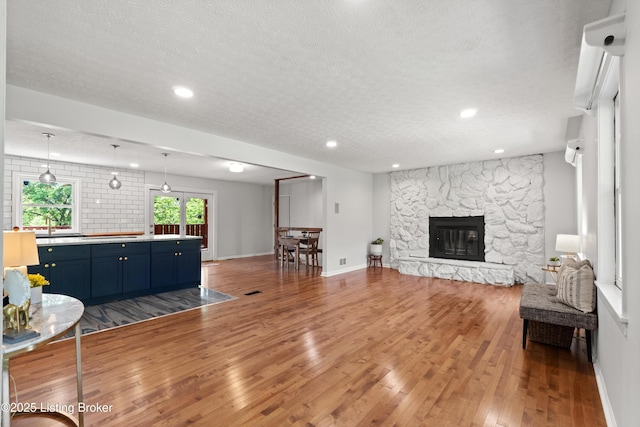 3304 S Camden Ln, Crestwood, KY 40014 - living area with a textured ceiling, wood finished floors, a stone fireplace, baseboards, and recessed lighting