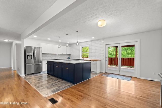 3304 S Camden Ln, Crestwood, KY 40014 - kitchen featuring stainless steel fridge, white cabinetry, light countertops, decorative backsplash, and light wood-style floors
