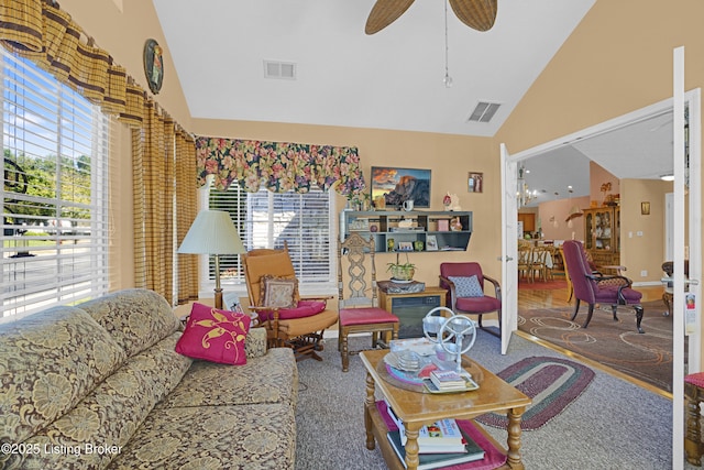 living area featuring vaulted ceiling, healthy amount of natural light, ceiling fan, and baseboards