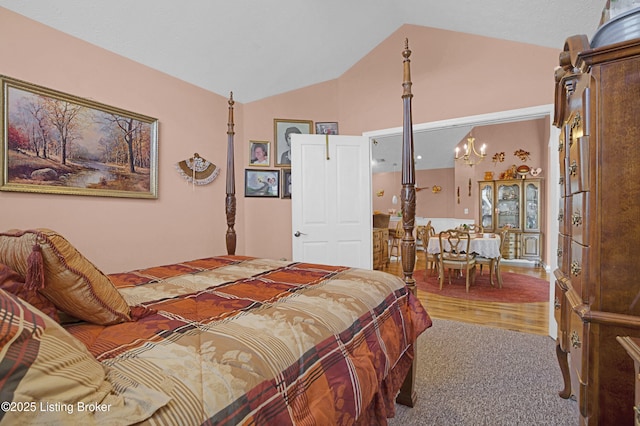 bedroom featuring lofted ceiling, carpet, and a chandelier