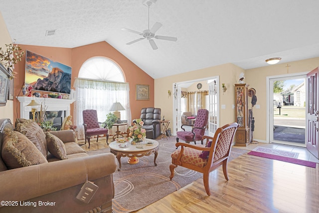 living area with a ceiling fan, light wood-style floors, and high vaulted ceiling