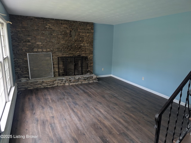 2227 Bradford Dr, Louisville, KY 40218 - unfurnished living room featuring dark wood finished floors, a stone fireplace, and baseboards