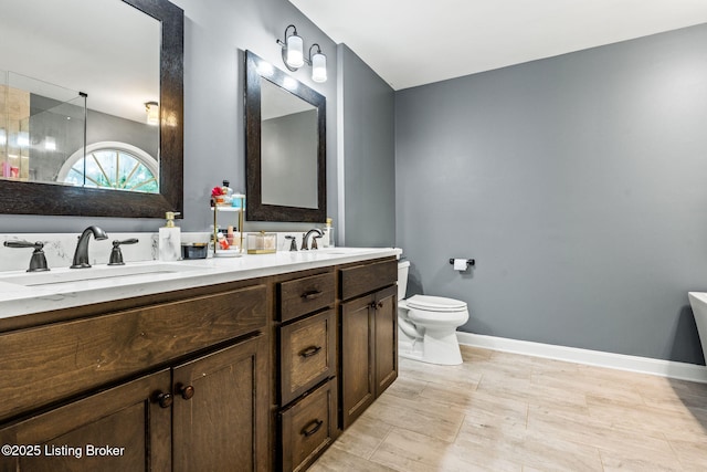1093 W Bryan Rd, Elizabethtown, KY 42701 - bathroom with toilet, baseboards, and double vanity