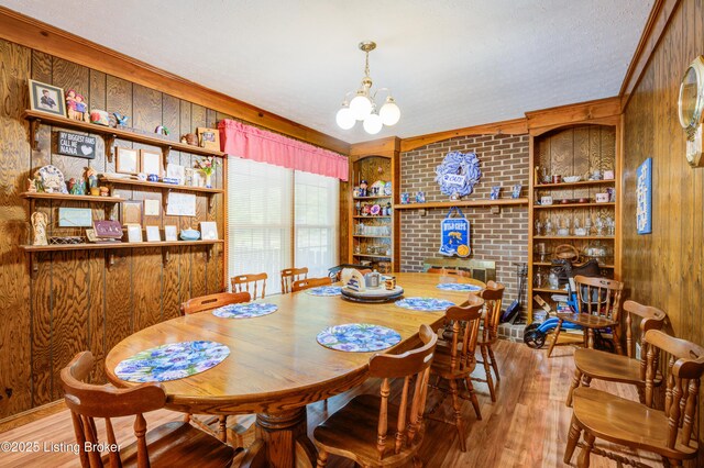 7003 Red Plum Ter, Pewee Valley, KY 40056 - dining room with wooden walls, wood finished floors, a chandelier, crown molding, and built in shelves