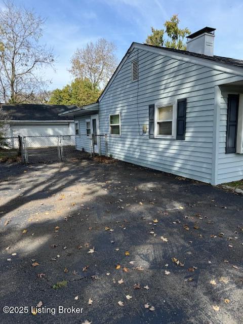 216 Bonnie Ln, Louisville, KY 40218 - view of home's exterior with fence and a chimney