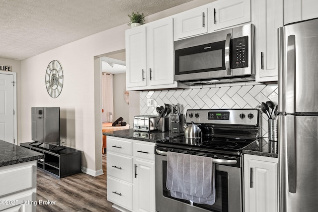 1136 Euclid Ave, Louisville, KY 40208 - kitchen featuring stainless steel appliances, a textured ceiling, decorative backsplash, white cabinetry, and dark wood-type flooring