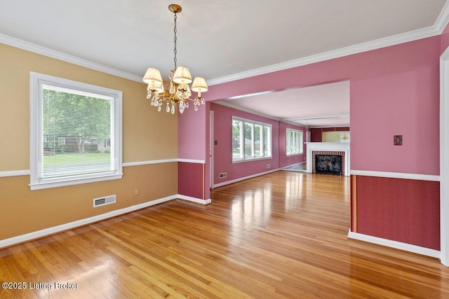 3531 Graham Rd, Louisville, KY 40207 - unfurnished living room featuring light wood-type flooring, a chandelier, crown molding, and a fireplace