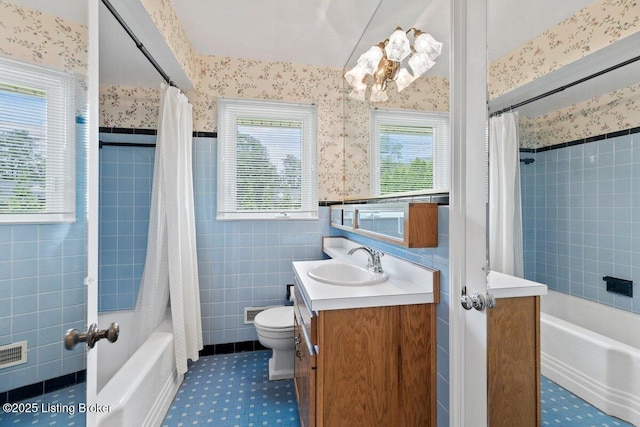 3531 Graham Rd, Louisville, KY 40207 - full bathroom featuring wallpapered walls, shower / bathtub combination with curtain, vanity, tile walls, and a wainscoted wall