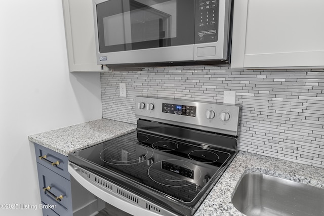 530-532 E Burnett Ave, Louisville, KY 40217 - kitchen with appliances with stainless steel finishes, backsplash, light stone counters, and white cabinets