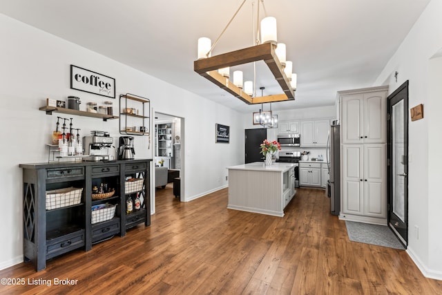 1609 Tall Oaks Dr, Jeffersonville, IN 47130 - kitchen featuring appliances with stainless steel finishes, a kitchen island, dark wood finished floors, pendant lighting, and a chandelier
