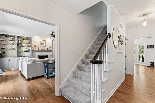 1609 Tall Oaks Dr, Jeffersonville, IN 47130 - stairs with ornamental molding, hardwood / wood-style floors, a ceiling fan, and a brick fireplace