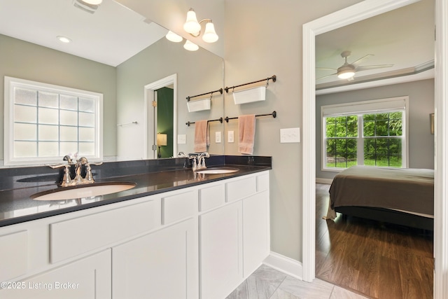 566 Wooded Falls Rd, Louisville, KY 40243 - full bath with double vanity, baseboards, connected bathroom, a ceiling fan, and marble look tiles