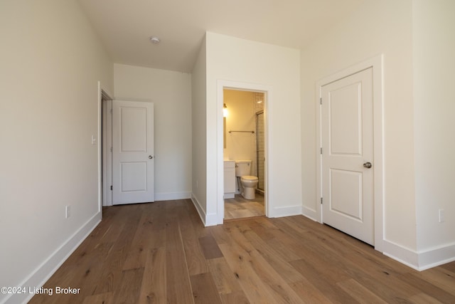 426 E Oak St, Louisville, KY 40203 - unfurnished bedroom with light wood finished floors, baseboards, and connected bathroom