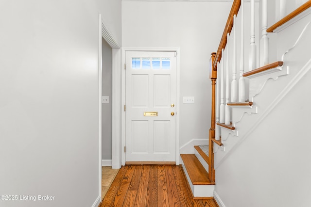 entrance foyer featuring stairs, baseboards, and wood finished floors