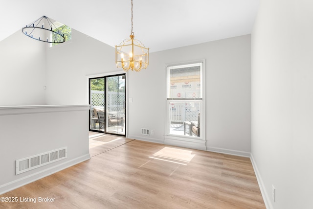unfurnished dining area with a chandelier, wood finished floors, and baseboards