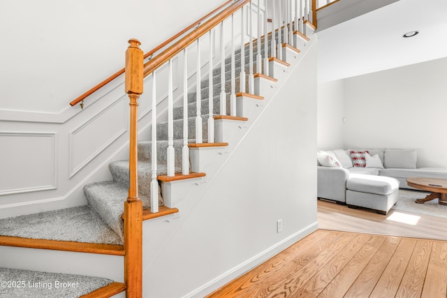 stairs with wood finished floors and baseboards