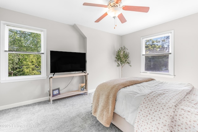 bedroom featuring multiple windows, baseboards, carpet, and a ceiling fan
