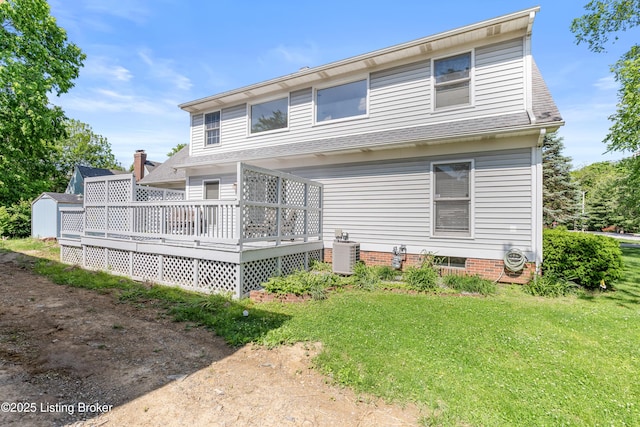 rear view of house featuring cooling unit, a wooden deck, and a lawn