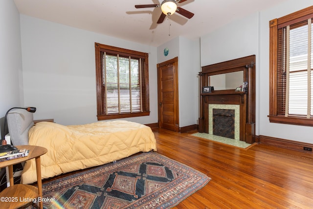 1629 Rosewood Ave, Louisville, KY 40204 - bedroom featuring hardwood / wood-style flooring, a fireplace with flush hearth, baseboards, and ceiling fan