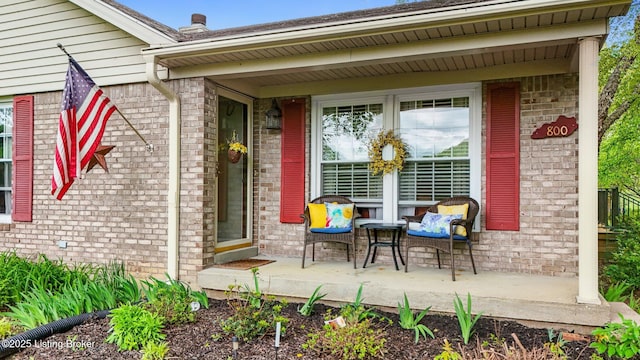 property entrance with brick siding and covered porch
