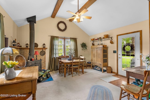 dining space featuring a wood stove, ceiling fan, and carpet flooring