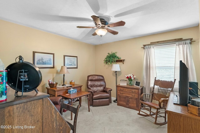 office area with a ceiling fan and light carpet
