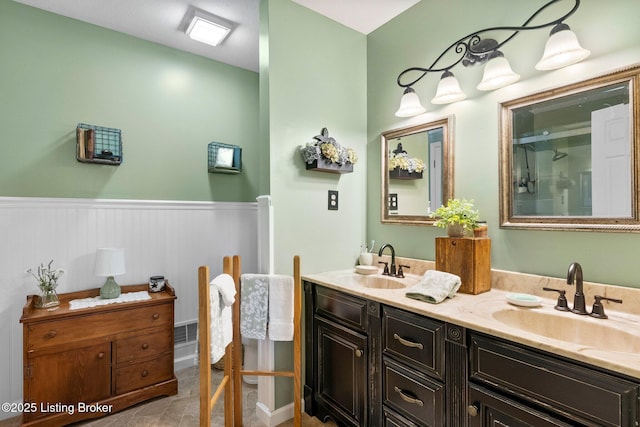 full bath with wainscoting, double vanity, and an enclosed shower