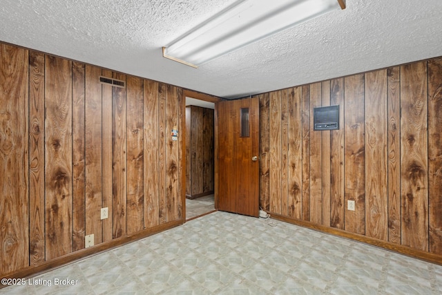 1160 Buck Knobs Rd, Ekron, KY 40117 - unfurnished room with tile patterned floors, a textured ceiling, wooden walls, and baseboards