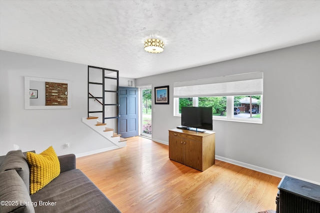 office space with light wood-style flooring, baseboards, and a textured ceiling